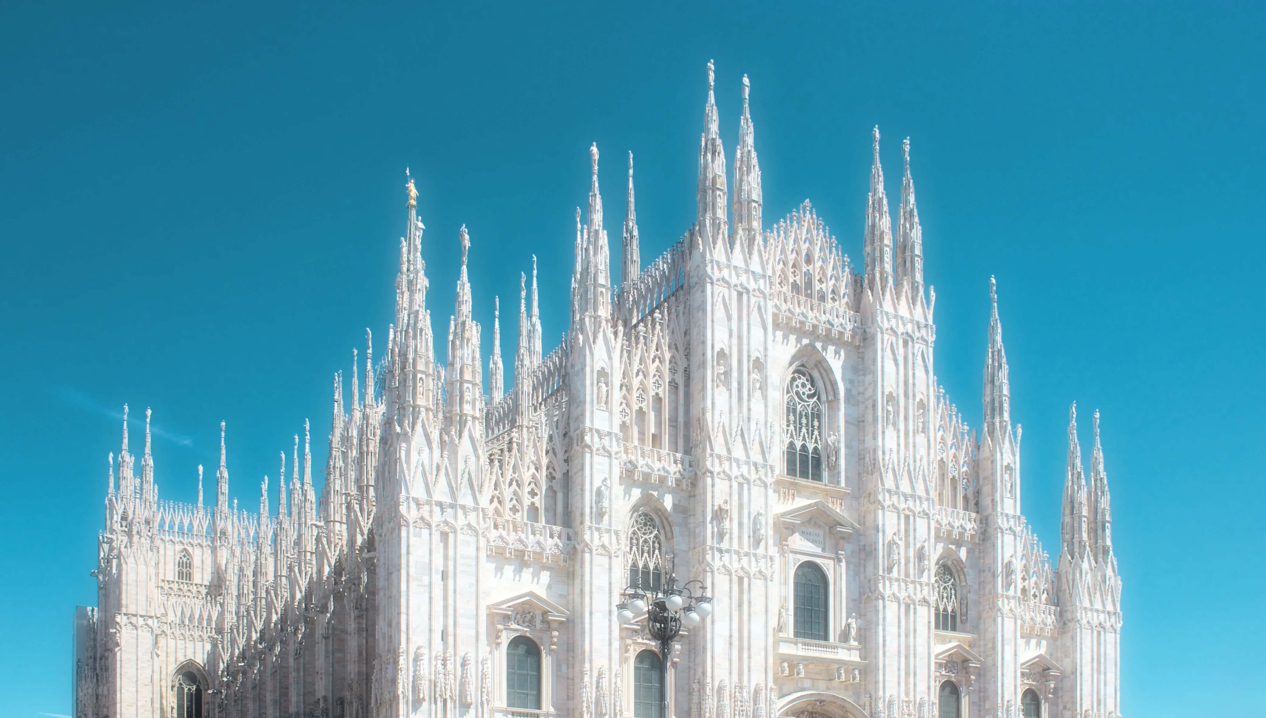 Photo of the gothic cathedral “Dumo di Milano” in Italy. Epic, bright, glowing, and radient.